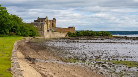 The rugged Blackness Castle stands out against the dramatic coastal backdrop the Firth of Forth guarding the coastal approaches.