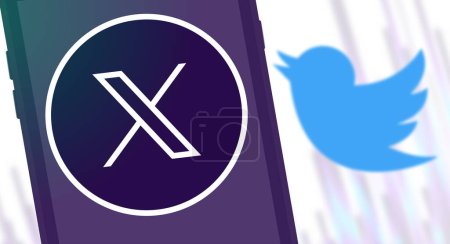 Foto de El nuevo logotipo de Twitter X en el grifo del teléfono y el borroso y antiguo logotipo de Twitter Bird. - Imagen libre de derechos