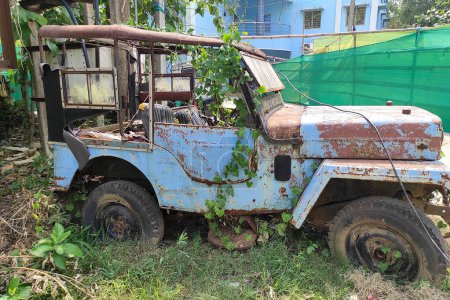 Téléchargez les photos : Un millésime rustique abandonné jeep ou van est laissé dans un état négligé dans le jardin - en image libre de droit