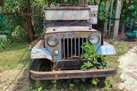 Téléchargez les photos : Un millésime rustique abandonné jeep ou van est laissé dans un état négligé dans le jardin - en image libre de droit