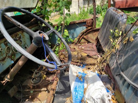 Téléchargez les photos : Photo de l'intérieur d'une jeep ou d'une camionnette abandonnée rustique laissée dans un état négligé dans le jardin - en image libre de droit