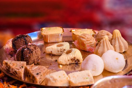 A variety of delicious sweets from Kolkata, West Bengal are arranged on brass plates. Selective focus