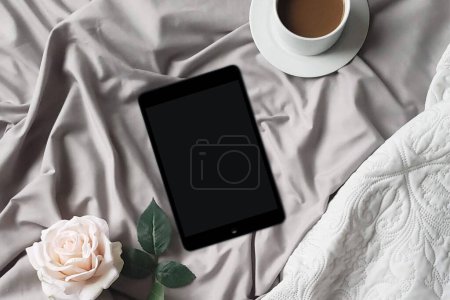 Photo for A cozy flat lay with a grey scarf, cup of hot chocolate, and tablet on a barn wood tabletop background for a comfy reading concept. - Royalty Free Image
