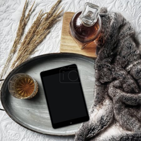Téléchargez les photos : Lifestyle plat composition laïque avec tablette PC moderne pour la lecture dans le concept de lit, ainsi que le whisky et le blé - en image libre de droit