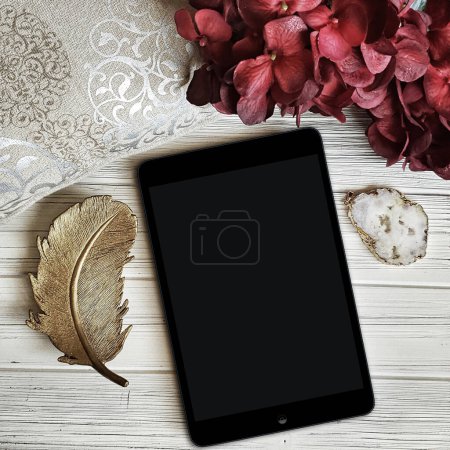 Foto de Maqueta de lectura ipad en blanco con flores en mesa de madera blanca - Imagen libre de derechos