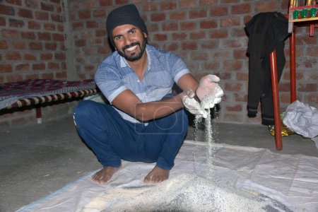 Téléchargez les photos : Fermier indien mélangeant différents éléments d'engrais dans le fumier, à la maison. focus sélectif - en image libre de droit