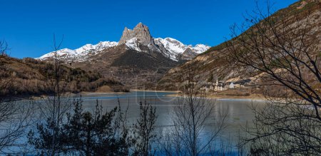 Foto de Embalse de Lanuza (Huesca), agua helada y primera nieve en las montañas. - Imagen libre de derechos