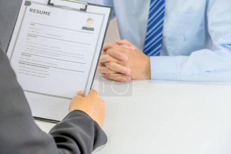 Photo for Office executives hand holding resume and interviewing job applicants in the meeting room. employer conversation summary work employment. - Royalty Free Image