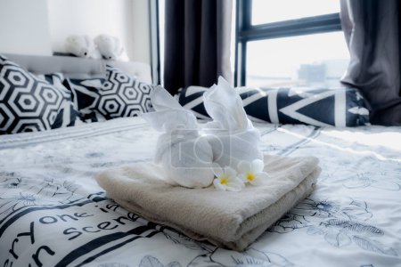 Plumeria y toallas en la cama en la habitación de hotel de lujo listo para viajes turísticos.