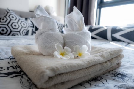 Plumeria and towels on the bed in the luxury hotel room ready for tourist travel.