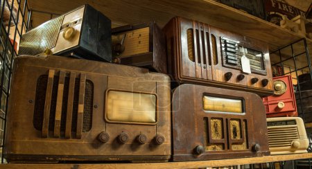 Foto de Una variedad de radios de mesa vintage agrupados en un estante en el interior vista de cerca - Imagen libre de derechos