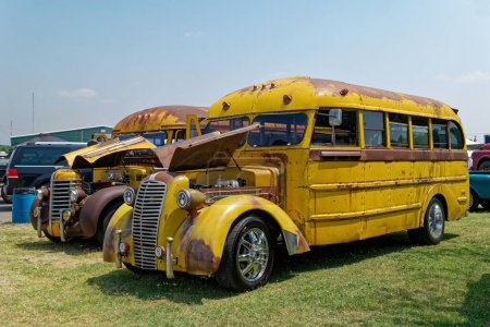 Photo for Lebanon, Tennessee USA - June 09, 2023  A pair of customize yellow with patina old vintage school buses with the hoods up for viewing - Royalty Free Image