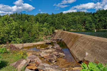 Téléchargez les photos : Un barrage au bord d'un lac avec un mur de ciment séparant les niveaux d'eau au parc de prairie Creek à Monterey Tennessee par une journée ensoleillée au début de l'automne - en image libre de droit