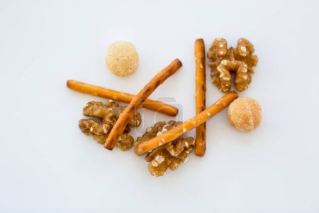 Téléchargez les photos : Snack mélange de noix et de bâtonnets de bretzel sur fond blanc - en image libre de droit