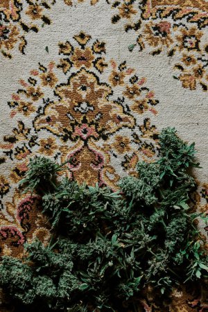 Téléchargez les photos : Des bourgeons de marijuana sur un très vieux tapis persan. Concept de cannabis et de drogue - en image libre de droit