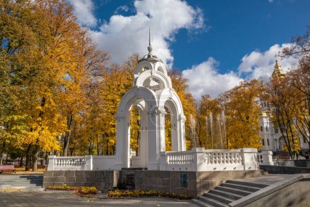 Mirror Stream alcove, fountain and Myrrh-bearing church in colorful yellow autumn Kharkiv city park with scenic sky, Ukraine