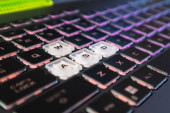Highlighted gaming keys with pink purple gradient light and blurred background. Powerful dark notebook keyboard close-up. Tech, IT, e-sport, computer science background Poster #646768496