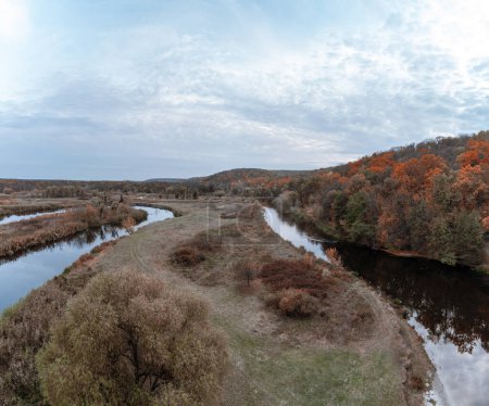 Luftaufnahme des Flusstals Siwerskyi Donez mit Herbstwald und wolkenverhangenem Himmel in der Ukraine