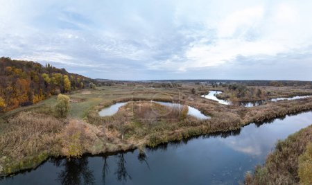 Aerial autumnal river curves panorama with autumn landscape and scenic cloudscape