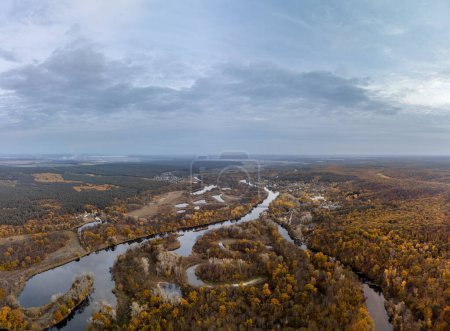 Aerial Siverskyi Donets river in autumn with wooded riverbanks and scenic sky in Ukraine
