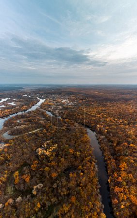 Aerial autumn river vertical panorama with forest on riverbanks and scenic clouds in Ukraine