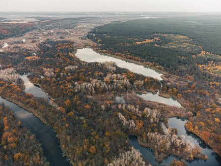 Autumn aerial valley with trees on riverbanks. Evening moody Siverskyi Donets River in Ukraine scenery
