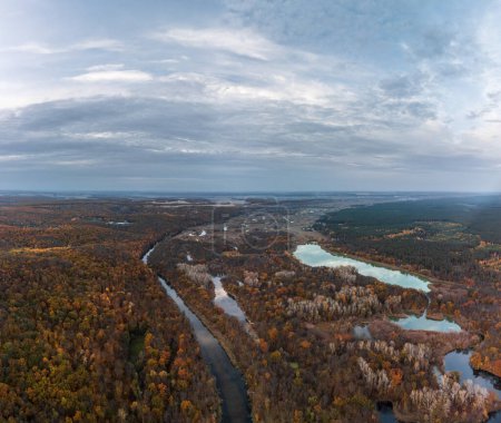 Aerial autumn Siverskyi Donets river with forest on riverbanks and dramatic clouds in Ukraine