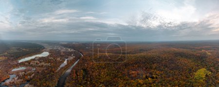 Aerial autumn Siverskyi Donets river sunny valley panorama with forest and epic sun in clouds view in Ukraine countryside