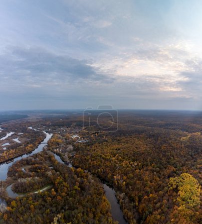 Aerial autumn river flowing in woodland of colorful autumnal Ukraine countryside