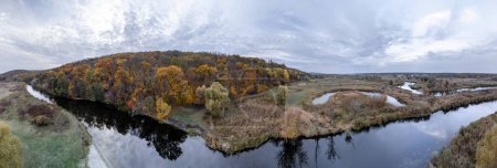 Aerial panorama of river valley in autumn with grey cloudy sky in Ukraine countryside