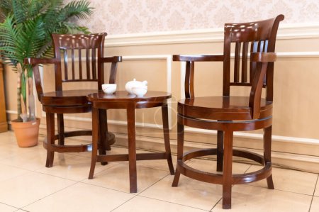 Foto de 2 sillas de madera de teca con mesa pequeña y decoración de mesa adicional y pequeño árbol - Imagen libre de derechos