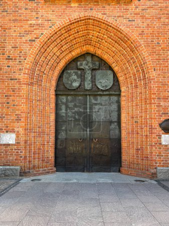 Téléchargez les photos : Une porte dans un mur de briques Façade ancienne en briques - en image libre de droit