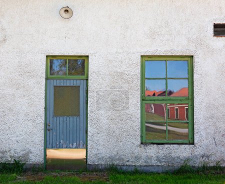 Eine Tür und ein Fenster zu einem alten weiß getünchten Haus in Robertsfors