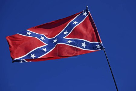 the american confederate flag against blue sky
