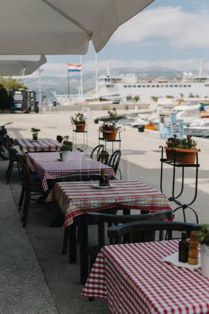Café vide sur le remblai à Supetar, île de Brac, Croatie. Destination voyage en Croatie.