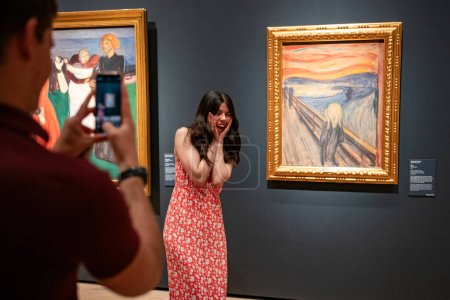 Téléchargez les photos : Oslo, Norvège, 20 juin 2023 : Les touristes observent la célèbre composition d'Edvard Munch The Scream à la National Gallery. Les visiteurs prennent des photos imitant la pose célèbre. - en image libre de droit