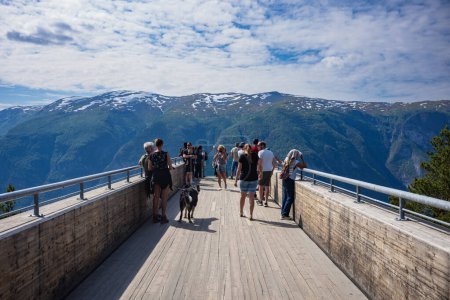Téléchargez les photos : Stegastein, Norvège, 24 juin 2023 : Les touristes profitent de la vue depuis le belvédère de Stegastein, à 650 mètres au-dessus d'Aurlandsfjord qui se trouve à flanc de montagne par la route panoramique Aurlandsfjellet. - en image libre de droit