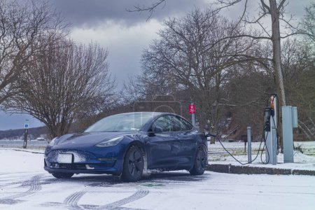 Photo for Trumansburg, NY, USA - Jan 14, 2023:  A Tesla Model 3 charges at a Level 2, ChargePoint station at Taughannock Falls State Park during a cold January winter. day. - Royalty Free Image
