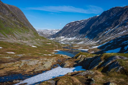 Téléchargez les photos : La neige a recouvert la vallée de Breiddalen au parc national de Jotunheimen en Norvège, le long de la route de Geiranger, pendant une journée d'été. - en image libre de droit