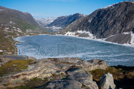 Téléchargez les photos : La neige a recouvert la vallée de Breiddalen au parc national de Jotunheimen en Norvège, le long de la route de Geiranger, pendant une journée d'été. Vue aérienne d'un lac gelé. - en image libre de droit