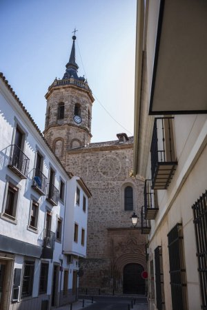 Tembleque, Spanien, ist ein kleines Dorf mit einer Kirche und einem Uhrturm im Zentrum, fotografiert an einem Sommertag ohne Wolken am Himmel. 