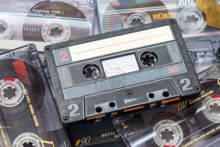 Foto de One audio cassette tape lying on a pile of audio cassettes lying on top of each other - Imagen libre de derechos
