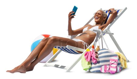 Foto de Mujer feliz en la playa en la silla de la cubierta de la playa, tomar el sol, utiliza el teléfono móvil, aislado en el fondo blanco, concepto unas vacaciones de playa de verano, compras en línea, viajes de reserva, y alojamientos resorts - Imagen libre de derechos
