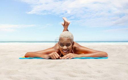 Glückliche junge Frau am Sandstrand liegend, an einem sonnigen Tag am Meer, Konzept eines Sommerurlaubs am Strand, Buchung von Reisen und Ferienunterkünften, Panorama mit Himmel und Meereshorizont zum Kopieren