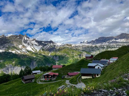 Téléchargez les photos : Breathtaking view of rural houses in village of Sion overlooking the snow-specked Swiss mountains. Idyllic shot of the rocky ridges surrounding a small alpine village in picturesque Switzerland. - en image libre de droit