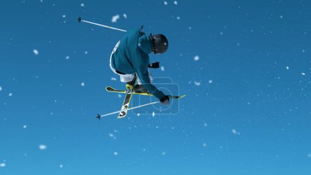 Foto de Athletic male tourist skiing in the Slovenian Alps jumps into air and performs a tumbling spin trick. Spectacular shot of a young male skier jumping off a massive kicker and doing a big grab trick. - Imagen libre de derechos