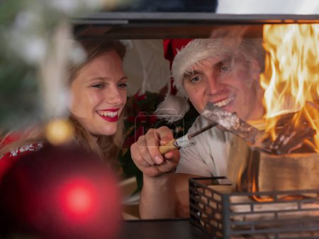 Photo for Affectionate young couple enjoying their time by the fire on Christmas day. Caucasian couple in love celebrating holidays by the living room fireplace in their decorated home on New Year's day - Royalty Free Image