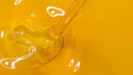 Téléchargez les photos : MACRO, TOP DOWN, DOF: Shiny unrefined organic flaxseed oil flows into a golden barrel. Viscous liquid streams into a container full of cold pressed olive oil. Natural face and body care ingredient - en image libre de droit