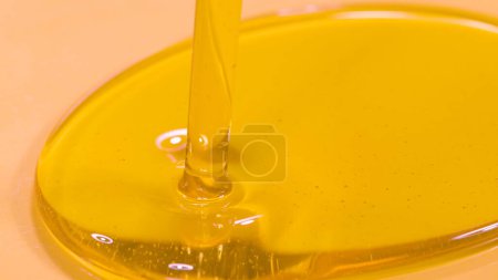 Téléchargez les photos : MACRO, DOF: Detailed shot of unrefined cold pressed walnut oil getting poured into a container. Delicious organic extra virgin olive oil flows into a deep dish. Natural hair and skin care product. - en image libre de droit