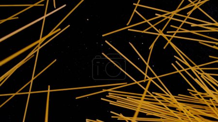 Foto de Abstract formation of falling raw spaghetti on black background. Famous Italian pasta ready for cooking and preparing delicious meal. Scattered raw spaghetti sheaf in artistic form. - Imagen libre de derechos